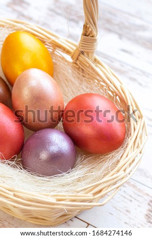 Easter eggs. colored eggs in a basket on Easter holiday. on a light background, wooden background. vertical photo
