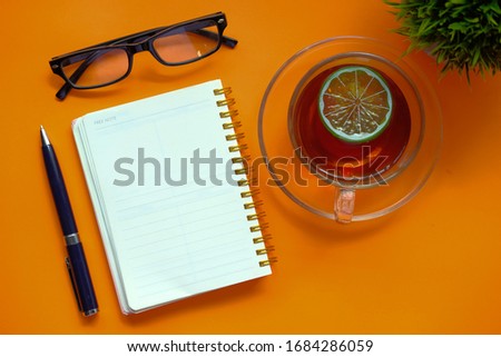 open notepad with pen and tea cup color background 