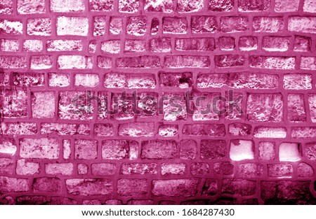 Wall made of old stones in pink tone. Abstract background and texture for design.