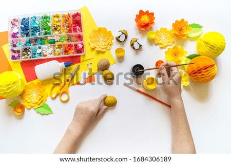 The child makes a bee crafts. Paints and material for creativity. Kindergarten and school. White background