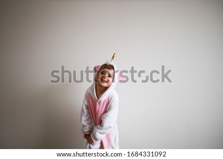 pretty girl wearing pink unicorn kigurumi and smiling
