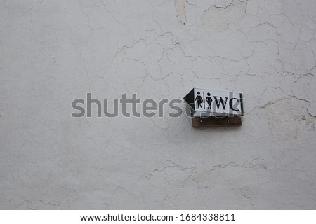 wc direction sign on the wall
