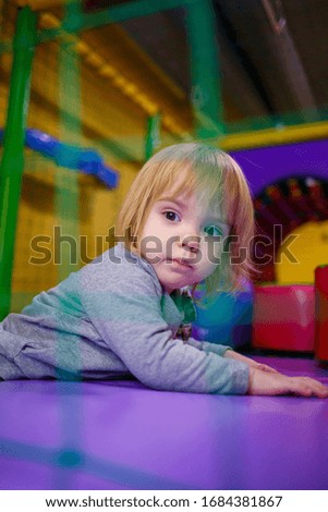 little girl 2 years old plays in a children's area with attractions