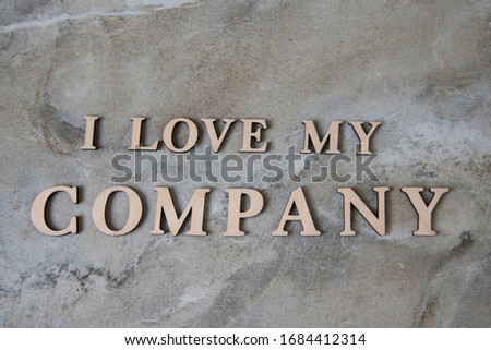 i love my company , writen wooden letters on stone background. Concep image.