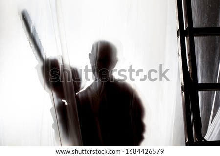 silhouette of man behind a plastic