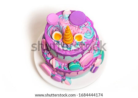 Birthday cake in the style of a multicolored unicorn. With decorations of marshmallows and macaroons.