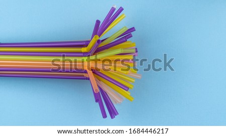 colorful straws for summer cocktails on light blue background with copy space. Top view. Drinking Straw Day, January 3. 