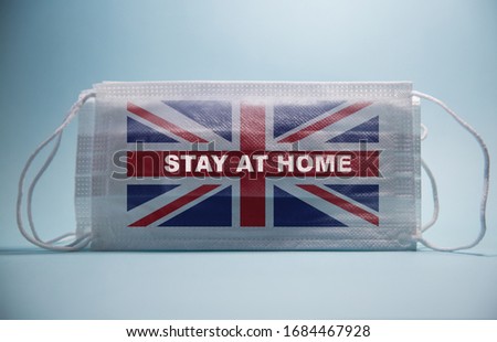 Coronavirus Stay At Home Warning Message And The Flag of the UK printed on a white surgical mask.Global economy hit by corona virus outbreak and pandemic Royalty-Free Stock Photo #1684467928