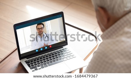 Focus on computer screen with confident happy male family doctor general practitioner consulting giving advices to older mature worried man patient with sickness symptoms online via video call. Royalty-Free Stock Photo #1684479367