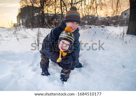 European boys play and fight, play in the snow in winter. Winter fun games.