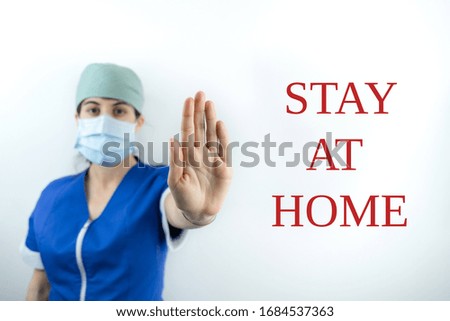 Doctor nurse showing a sign stay at home for Coronavirus Covid-19 with face mask
