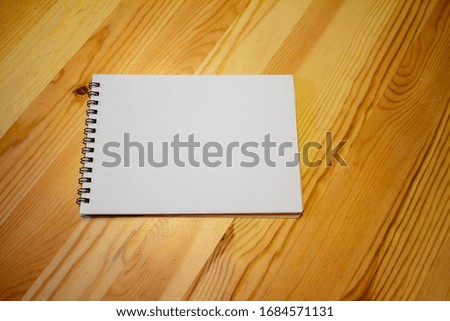 a white notebook on a wooden table