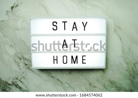 Stay at Home word letter in light box on marble background