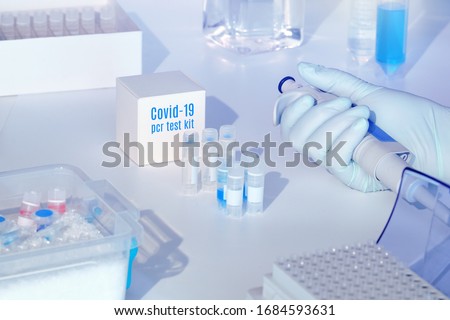 Quick novel coronavirus test kit. 2019 nCoV pcr diagnostics kit. Hand in glove with automatic pipette. RT-PCR kit to detect covid19 virus in clinical samples. Тest based on real-time PCR technology. Royalty-Free Stock Photo #1684593631