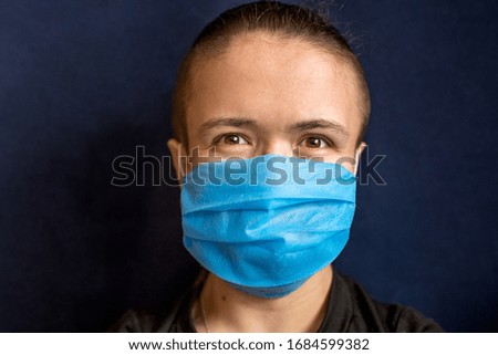 the man in a medical mask smiles and has a positive mood during a coronavirus pandemic