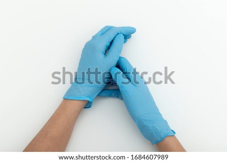 Hands in medical gloves on white table