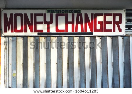 Hand painted sign outside a money changer shop in rural Indonesia