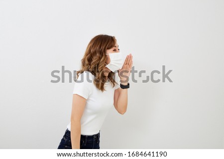 Young asian woman wearing a face mask isolated on bright gray background.  Flu epidemic, dust allergy, protection against virus. City air pollution concept