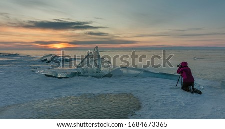 The Baikal Lake in winter with a surface covered with a thick layer of transparent cracked ice and ice hummocks at sunrise - Siberia, Russia