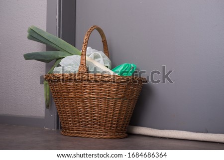 Shopping basket with goods and food  hanging at the front door to confined people at home, neighborhood help concept at quarantine time during the coronavirus pandemic Royalty-Free Stock Photo #1684686364