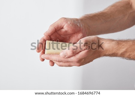 partial view of man using soap on grey background background