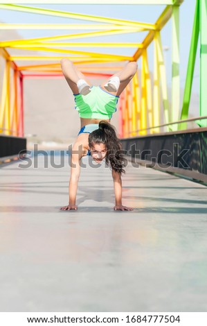 Beautiful young girl acrobat on the rainbow bridge