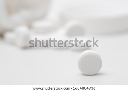 White pills in pill bottle on white background, Eat for pain relief.