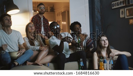 Close-up young cheerful sport fans watch game at home on TV, get upset and sad, support together with drinks slow motion