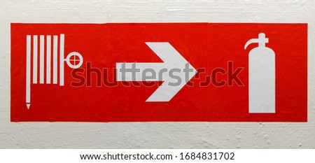 Sign indicating the location of the fire extinguisher and the direction of evacuation