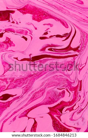 Abstract background of mixed shades of nail polish with a marble pattern and a shimer. Liquid colorful paint background creative watercolor bright pink