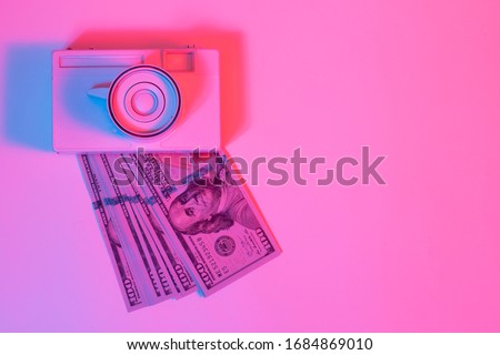 Vintage camera and money in vibrant bold gradient purple and blue holographic colors. Concept art. Minimal summer surrealism.