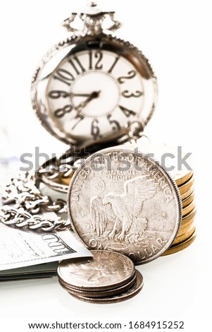 collage of an old metal dollar, coins with a blurry background in the form of a clock dial
