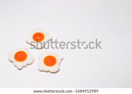 Three jelly fried eggs on the left on a white background, close-up. Sweet photo for your delicious design.
