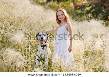Full length picture of a standing girl with her dog