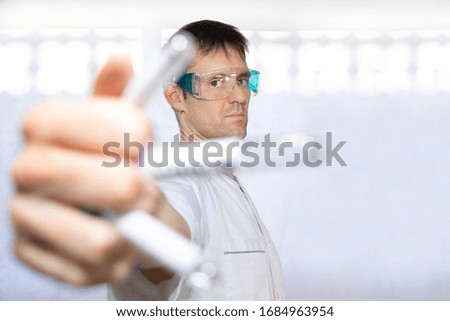 
nurse or doctor with mask, test tubes, safety glasses
