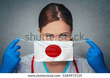Coronavirus in Japan Female Doctor Portrait hold protect Face surgical medical mask with Japan National Flag. Illness, Virus Covid-19 in Japan, concept photo
