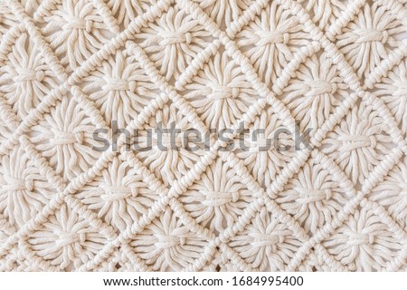 Close-up of hand made macrame texture pattern. ECO friendly modern knitting DIY natural decoration concept. Flat lay.