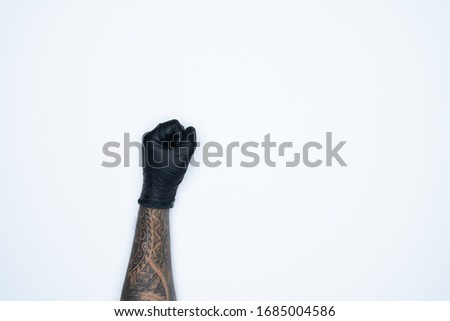 A man hand and gestures in Black rubber glove shows fist scat sign isolated on white background.