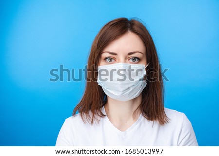 Brunette woman wearing aseptic mask. light blue background Royalty-Free Stock Photo #1685013997