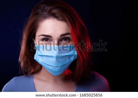 Portrait of confident woman wearing medical protective mask. Studio shot. Black background