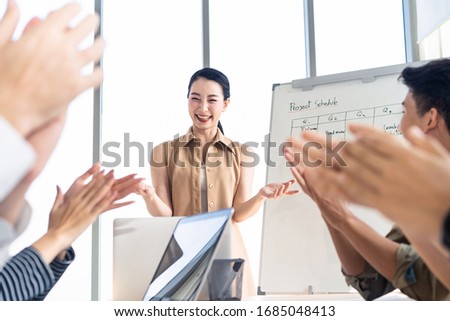 Asian smart woman present work and got praise and complement from team colleague. People applaud hands with happy smile congratulation in meeting room. Business finance, communication planning concept Royalty-Free Stock Photo #1685048413