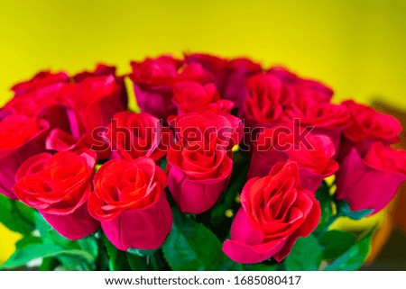 Artificial red rose bouquet flower with yellow wall background to decorated in the living room on love day.