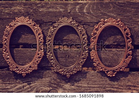 old oval frame for photos  on a wooden background