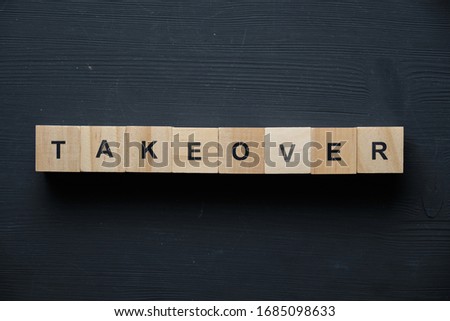 Modern business buzzword - takeover. Top view on wooden table with blocks. Top view. Close up. Royalty-Free Stock Photo #1685098633