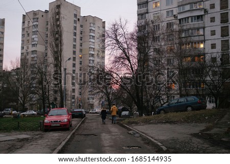 Two people walk down street in Kiev in pink sunset