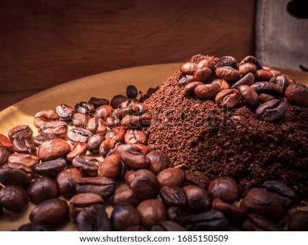Coffee beans and ground powder on a wooden plate