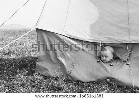 Little boy in the tent. Black and white toned photo.