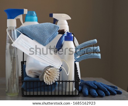 Koronavirus. The idea of general cleaning of the house during quarantine. A medical protective mask on plastic dusters with environmental cleaners on a natural wooden background. Spend time at home.  Royalty-Free Stock Photo #1685162923
