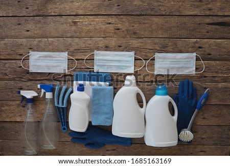 Koronavirus. The idea of cleaning the house during quarantine. Medical protective masks and plastic rubble with cleaning and disinfectants on a natural wooden background. Spend time at home.  Royalty-Free Stock Photo #1685163169