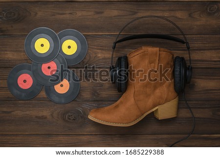 Vinyl discs, boots, headphones on a wooden background. Concept of folk music.